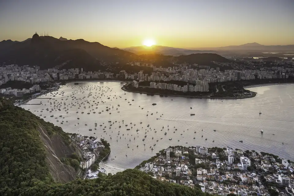 Río de Janeiro al atardecer desde el Pan de Azúcar: la bahía de Botafogo con veleros, los edificios de la costa y el Cristo Redentor sobre el Corcovado, a contraluz