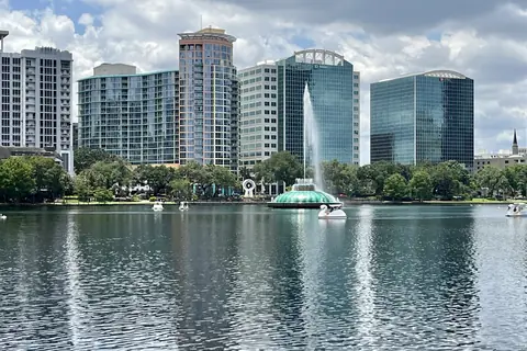 Vista del lago Eola en Orlando con la fuente Linton Allen en primer plano y los rascacielos del centro reflejados en el agua